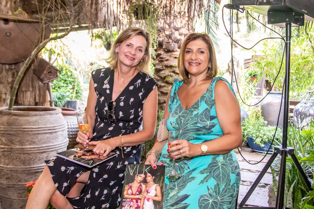 A imagem mostra duas convidadas do evento No Jardim da Moda
